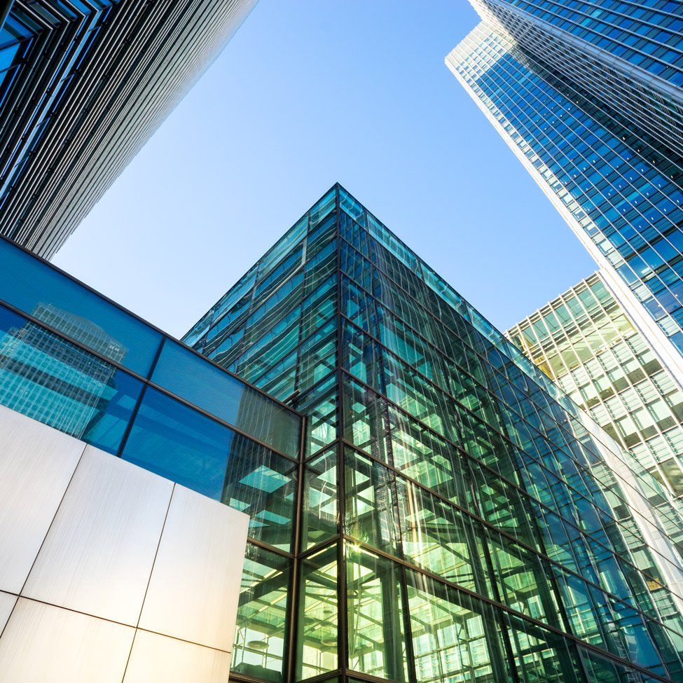 Modern glass and steel skyscrapers against a clear blue sky.