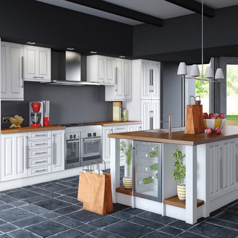 A modern kitchen with white cabinets, gray walls, and a wooden countertop island. Two brown paper bags sit on the floor.