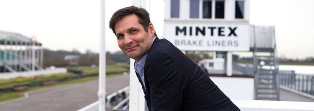 Man leaning on a railing smiling, with