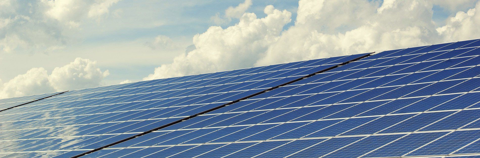 Solar panels against a cloudy sky.