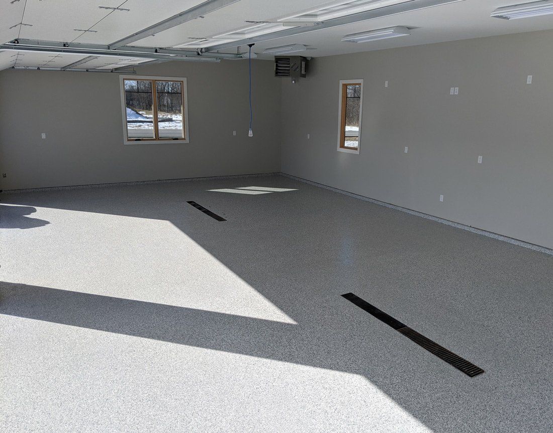 A large empty room with a lot of windows and a concrete floor.
