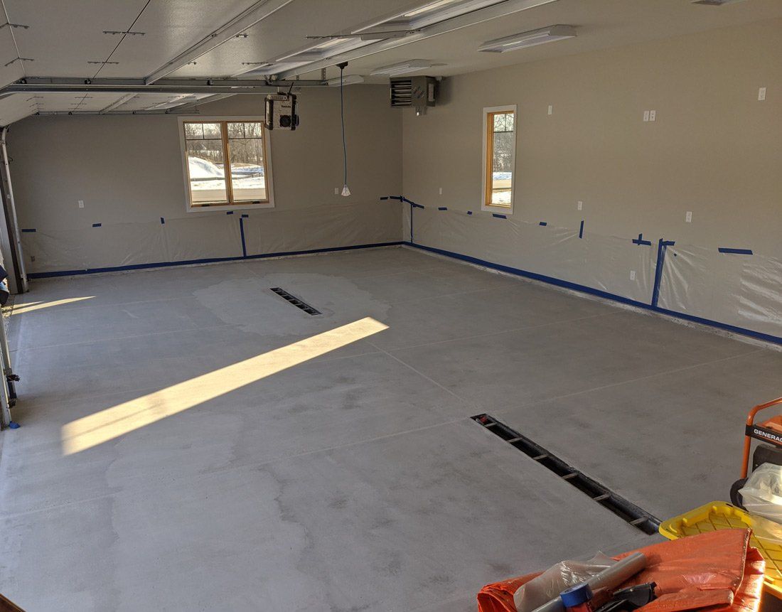 A large empty room with a lot of windows and tape on the walls.