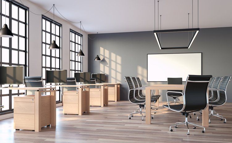an empty office with a white board on the wall