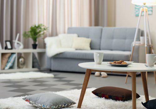 sala con divano grigio e primo piano di un tavolino