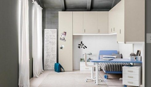 cameretta con scrivania blu e mobili bianchi