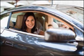 A young business women driving a corporate car