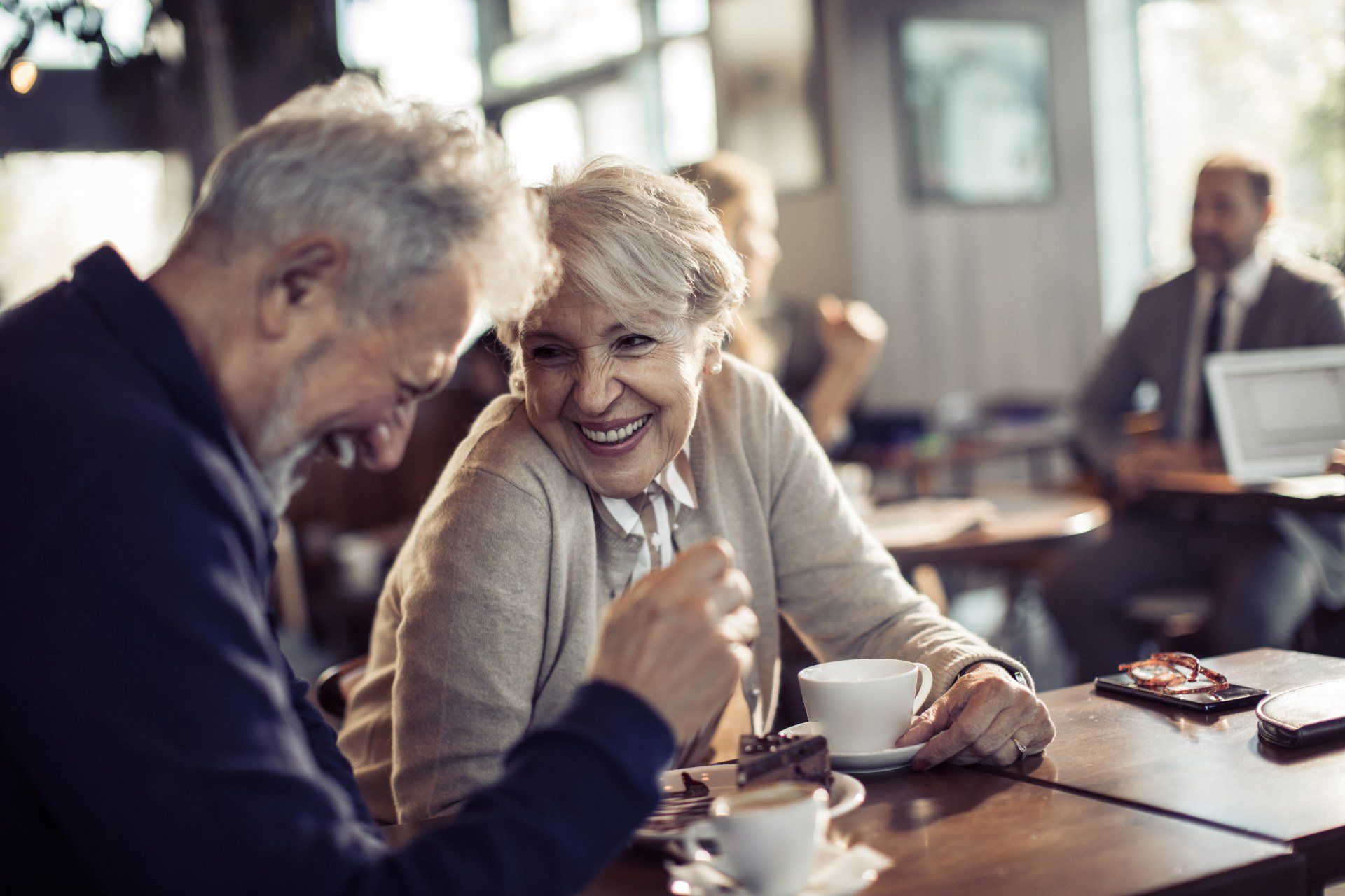 Due persone portatrici di protesi acustiche che discutono amichevolmente