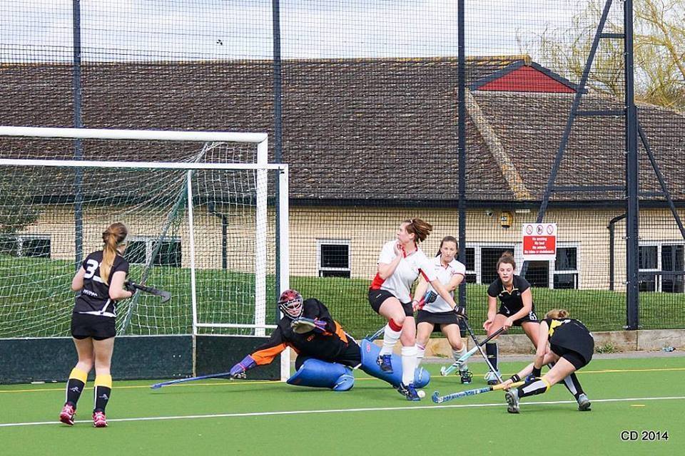 A group of women are playing field hockey on a field.