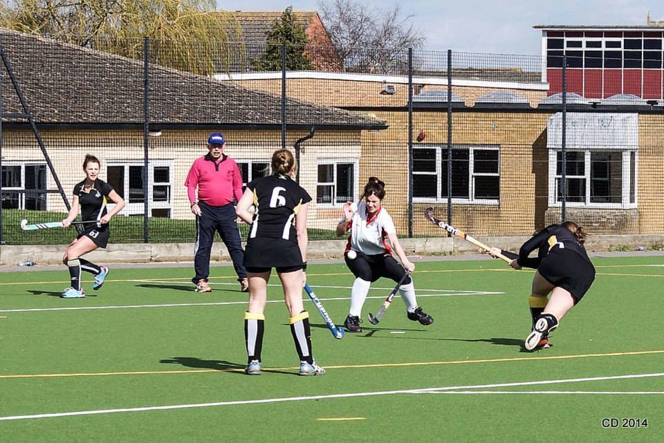 A group of women are playing field hockey on a field