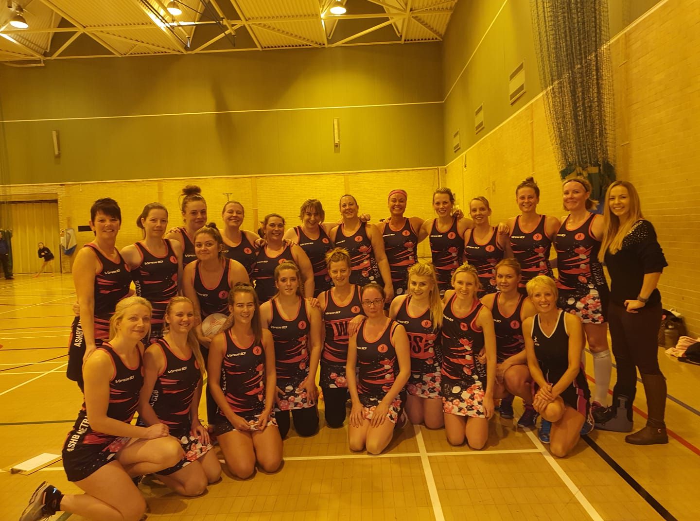A group of women are posing for a picture in a gym