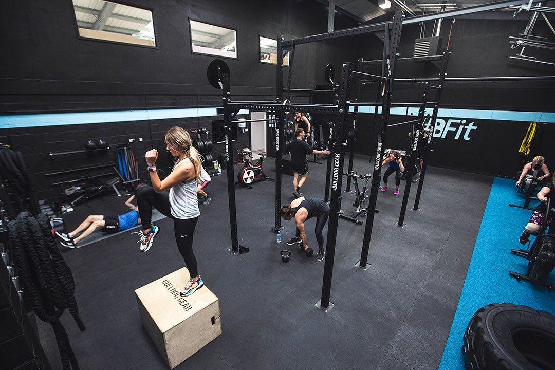 A group of people are doing exercises in a gym.