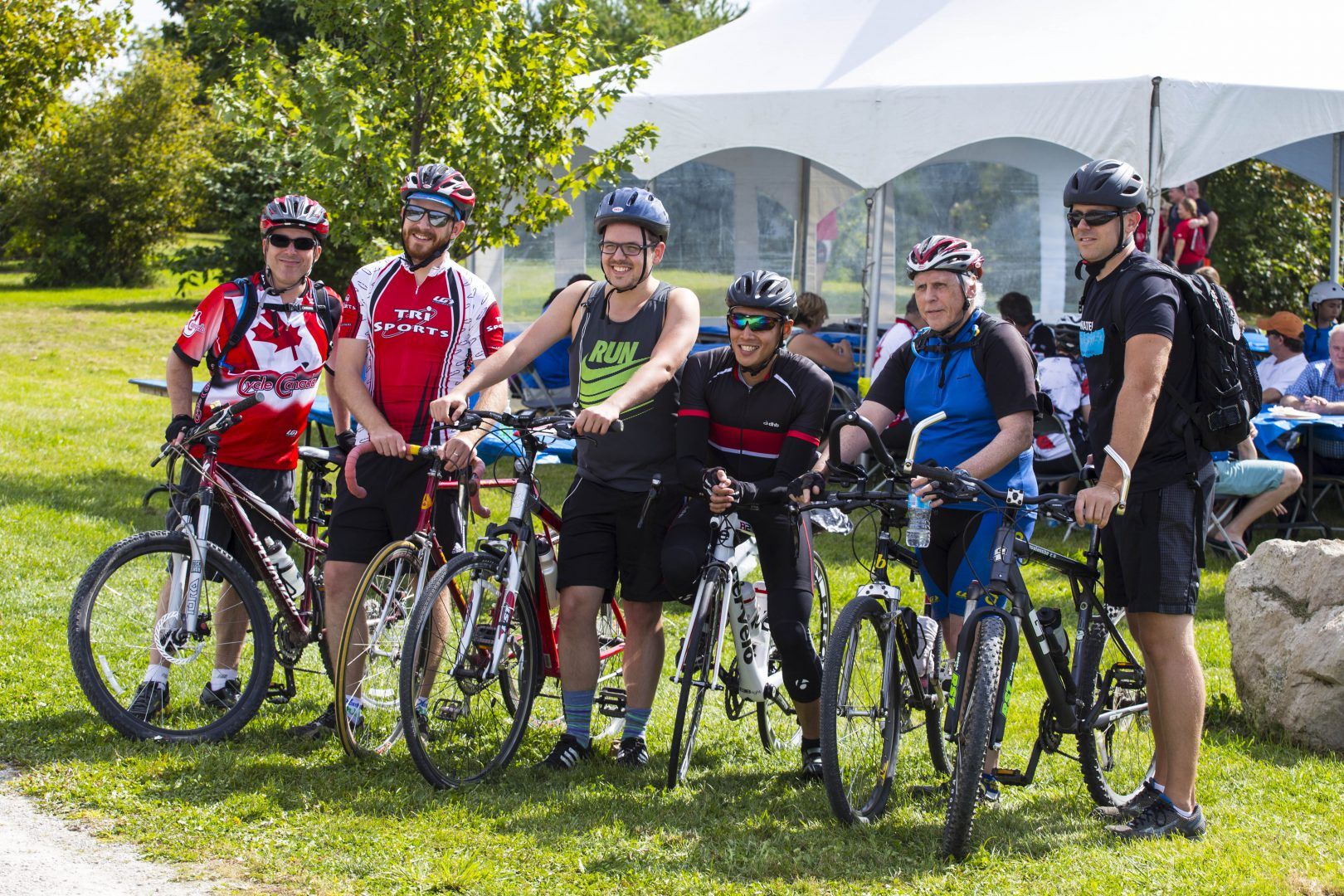 A group of cyclists are posing for a picture with their bikes