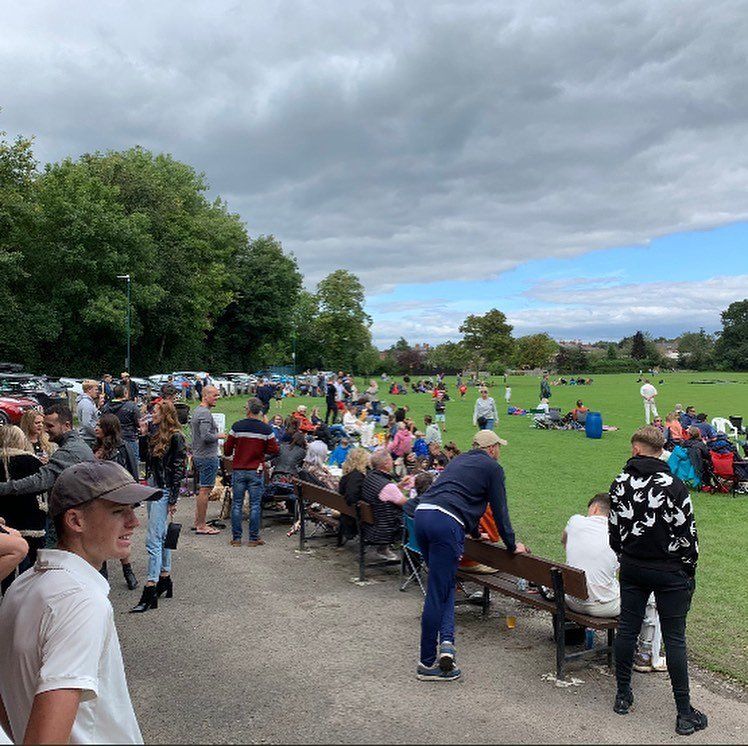 A large group of people are gathered in a park