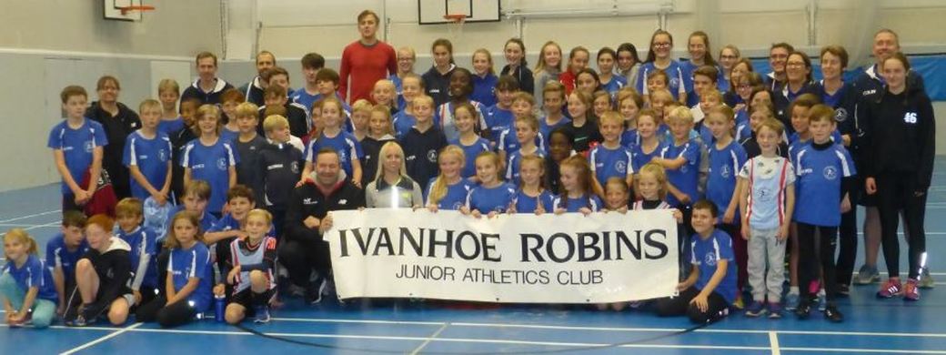 A group of people posing for a picture with a sign that says ivanhoe robins