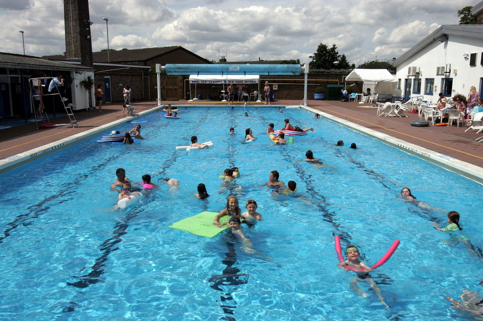 A group of people are swimming in a large swimming pool