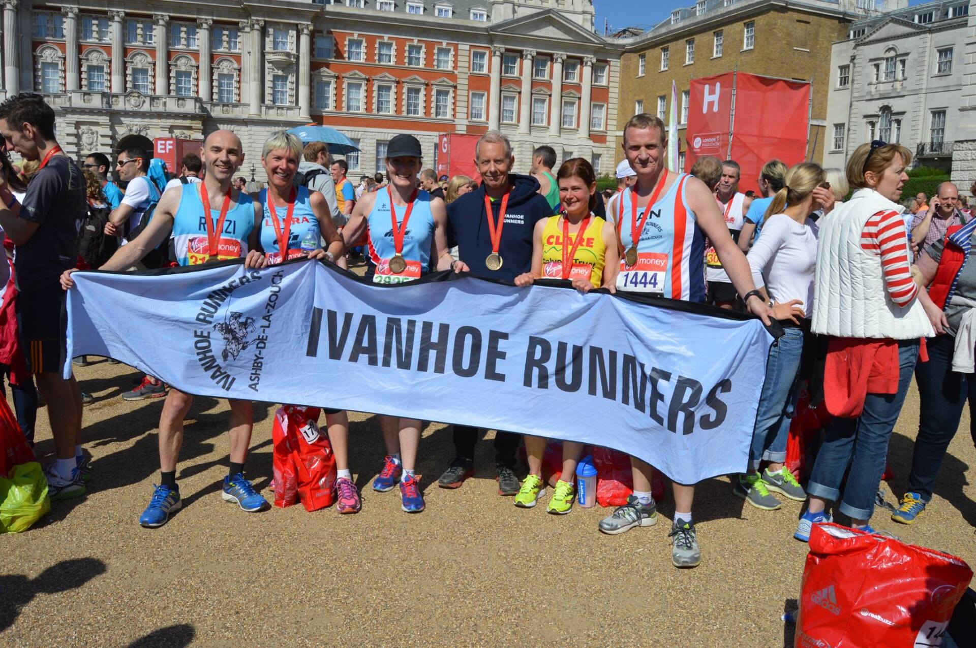 A group of people holding a banner that says ivanhoe runners