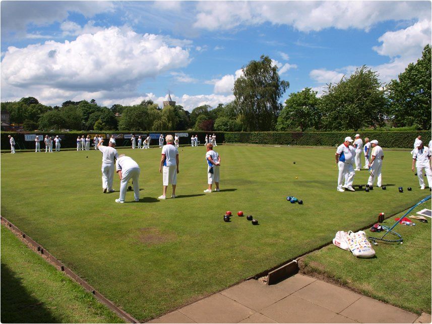 A group of people are playing a game of lawn bowling