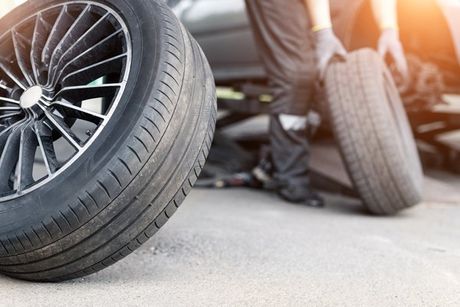 Mechanic replacing a car wheel — Lawrence, KS — Lighthouse Tow & Recovery Mechanic replacing a car wheel — Lawrence, KS — Lighthouse Tow & Recovery