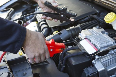 Mechanic doing a car engine jump start — Lawrence, KS — Lighthouse Tow & Recovery