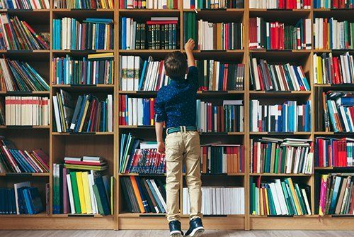 un bambino che cerca un libro in una libreria