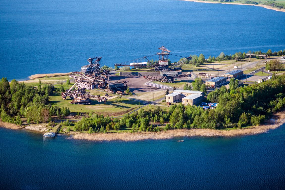 Insel mit Industrieanlagen und Gebäuden, umgeben von blauem Wasser.