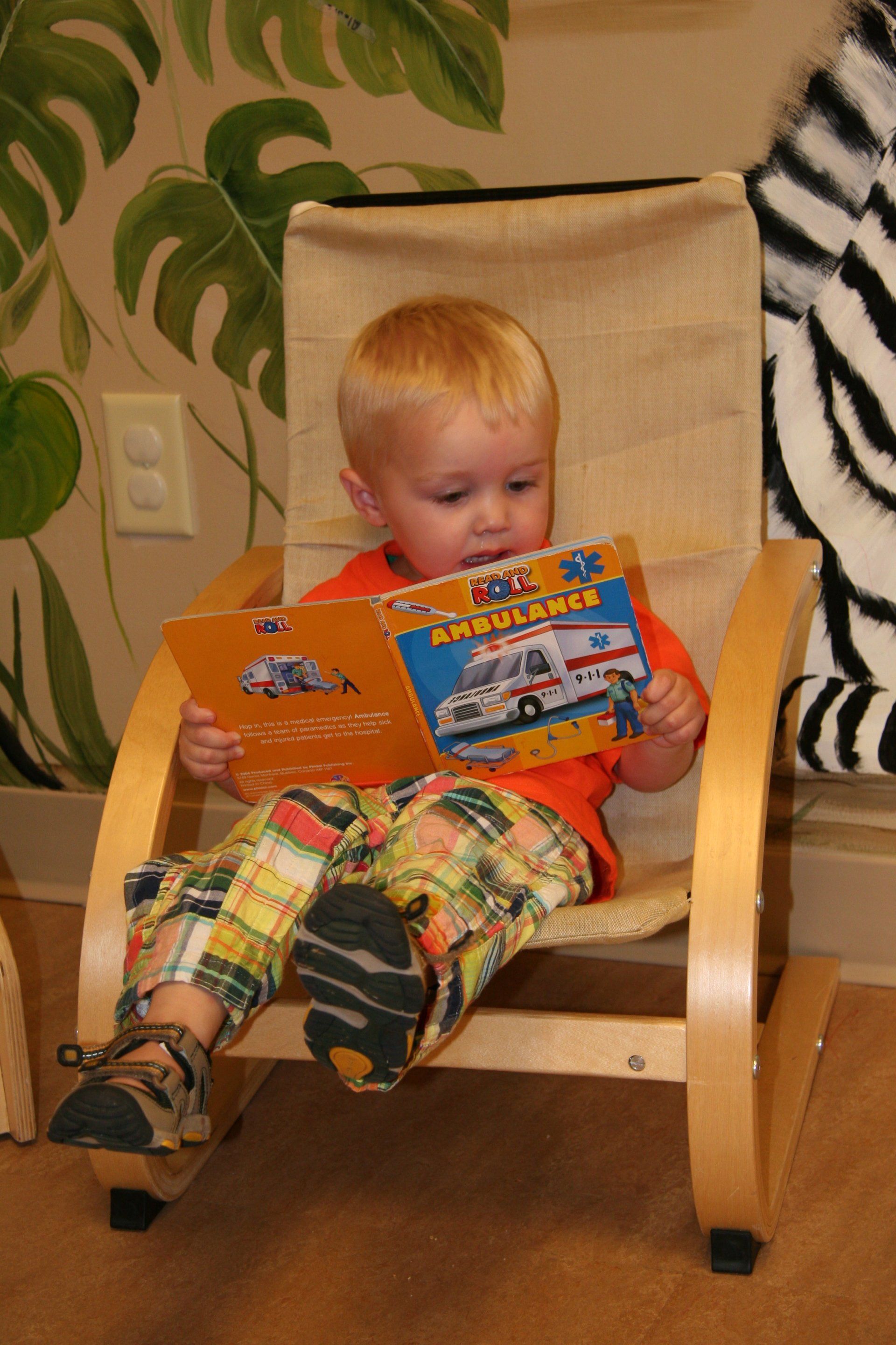 Young boy reading an ambulance book.