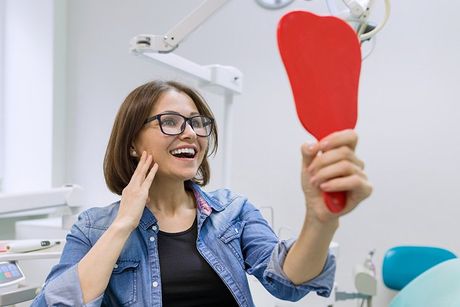 women in examination room with mirror in hands