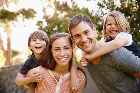 family smiling with trees