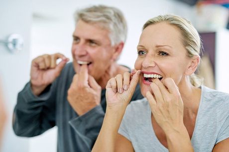 women and man flossing inside bathroom