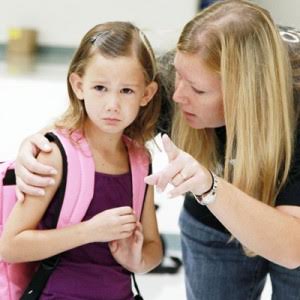 Sad young girl with her Mom assuring her she can go to school