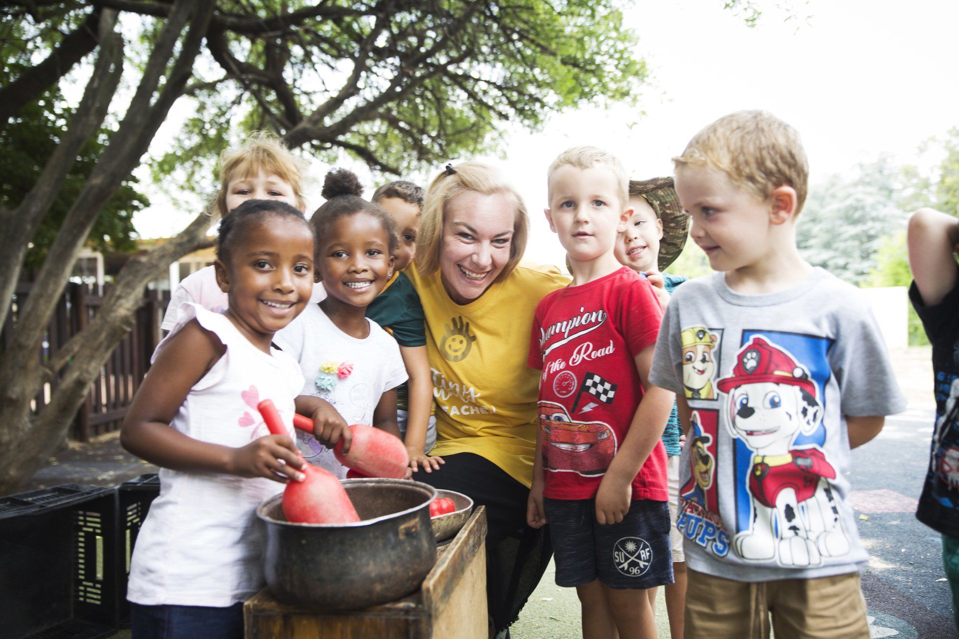 A group of children are posing for a picture with a teacher.