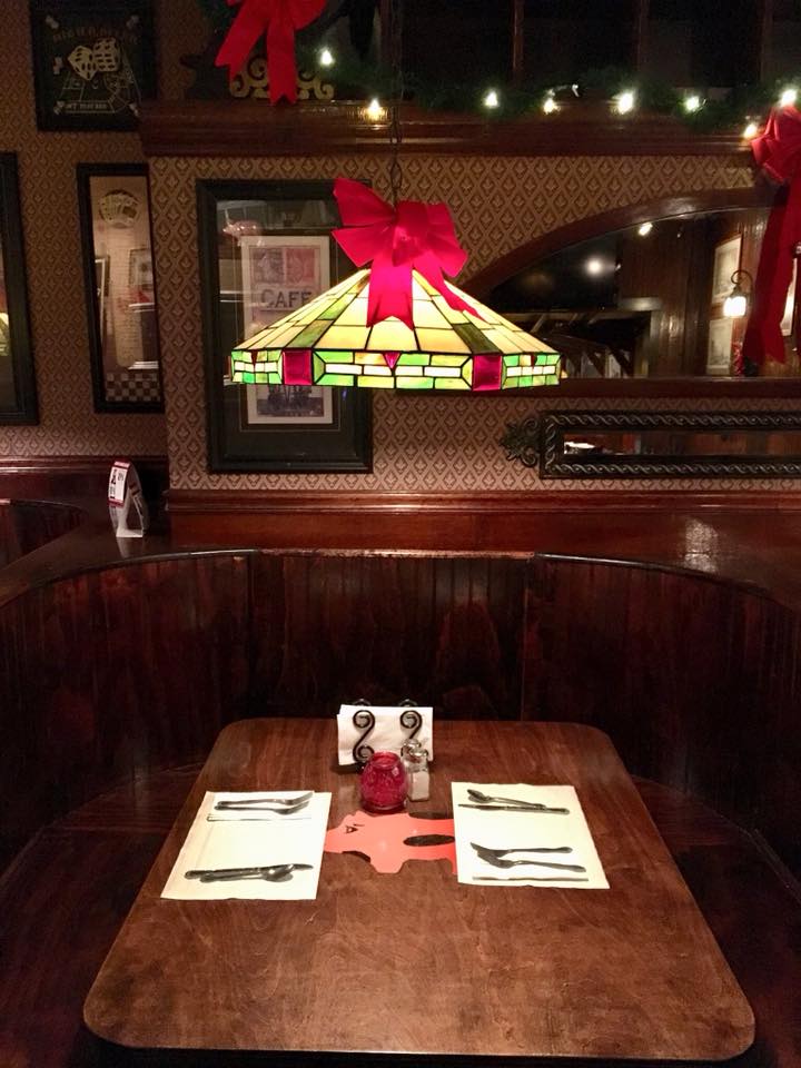 interior booth of dark wood with a Tiffany style lamp over it