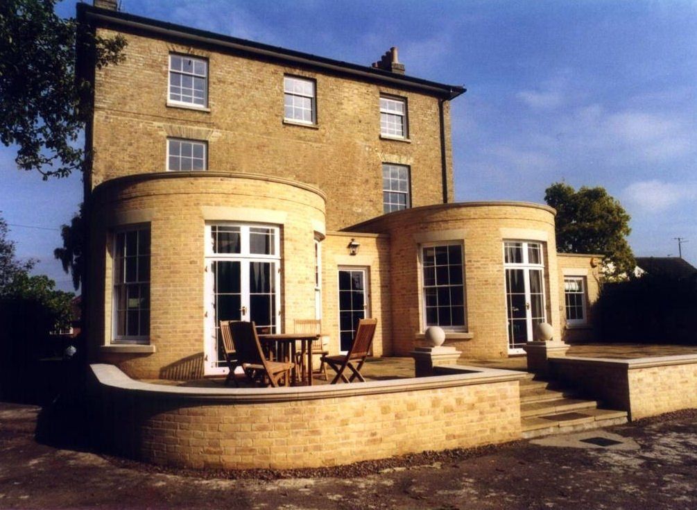 A large brick house with a circular patio area in front of it