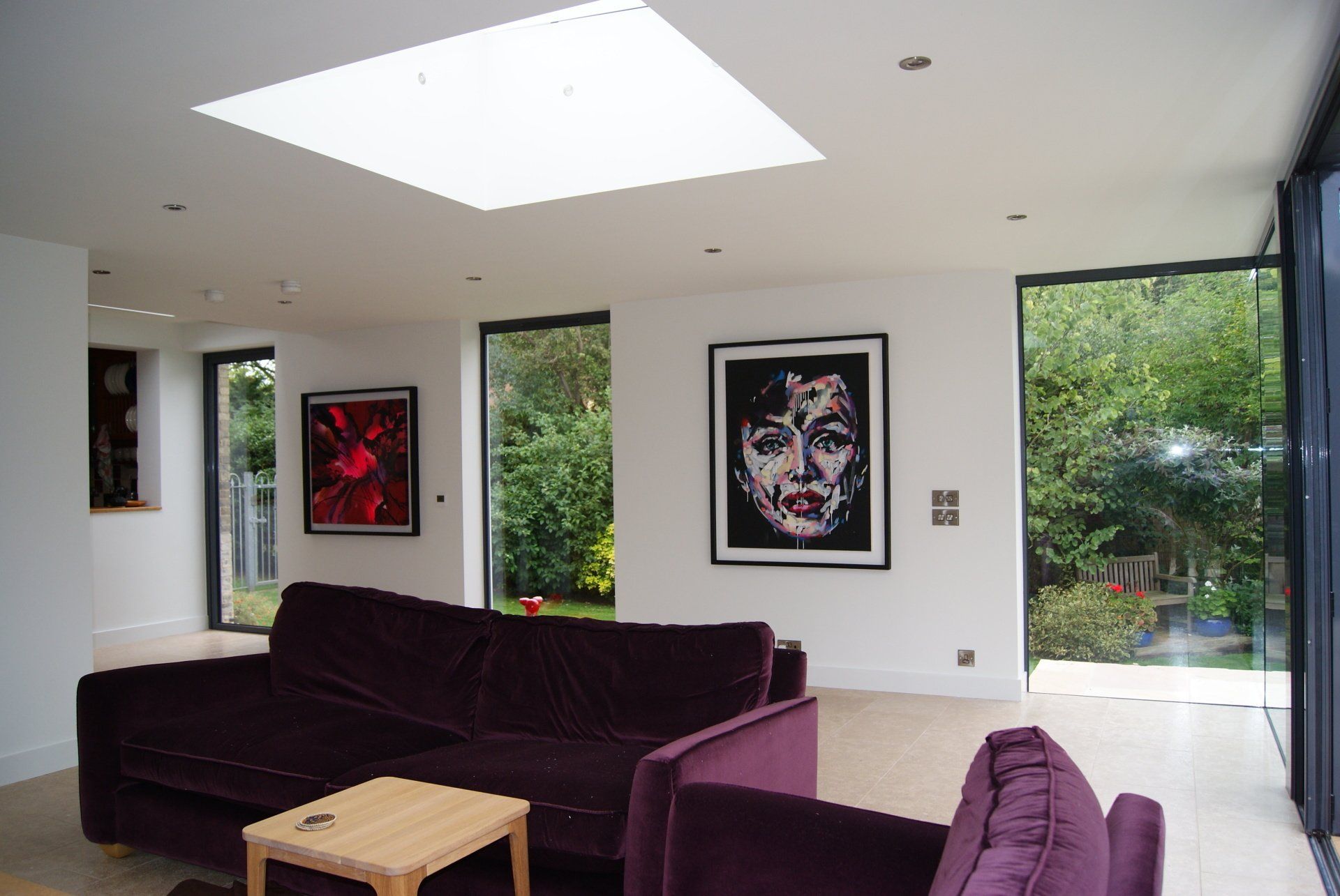 A living room with a purple couch and a painting on the wall