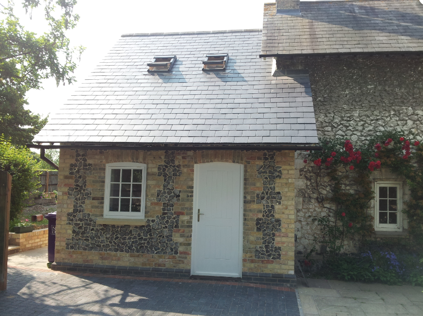 A brick building with a slate roof and a white door