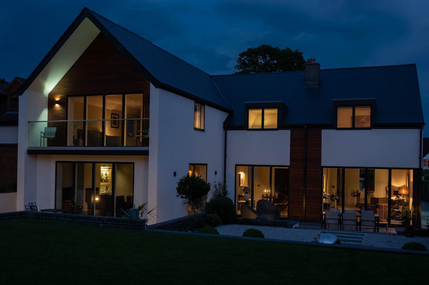 A large house with a lot of windows is lit up at night.