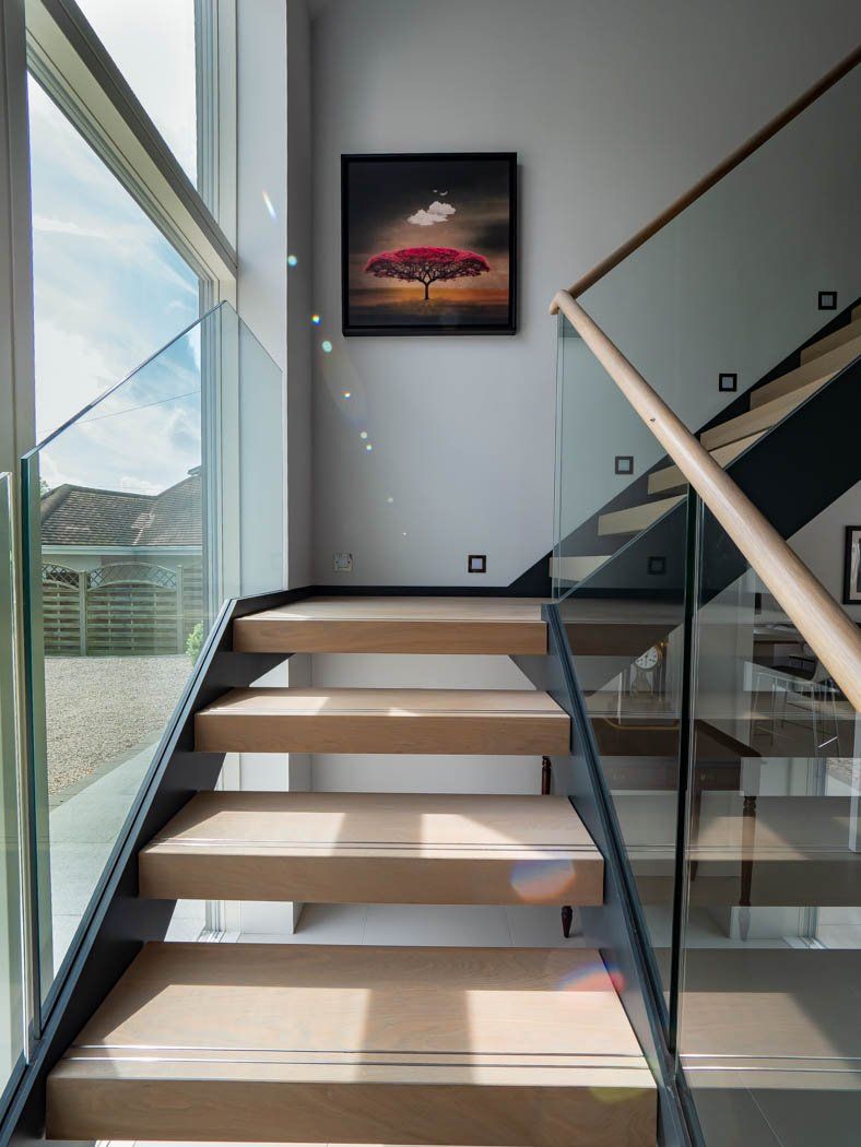 A staircase with a picture on the wall above it