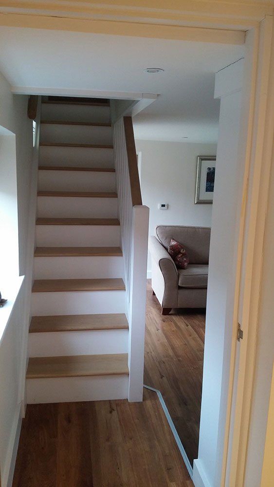 A staircase leading up to a living room with a couch.
