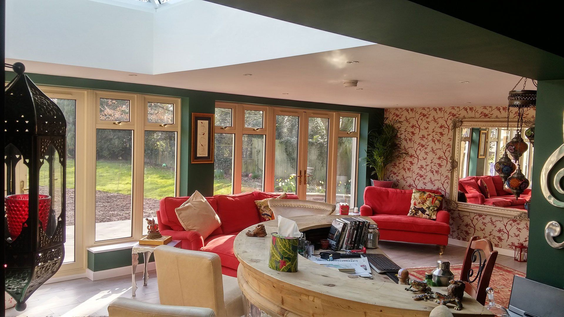 A living room with a red couch and a lot of windows