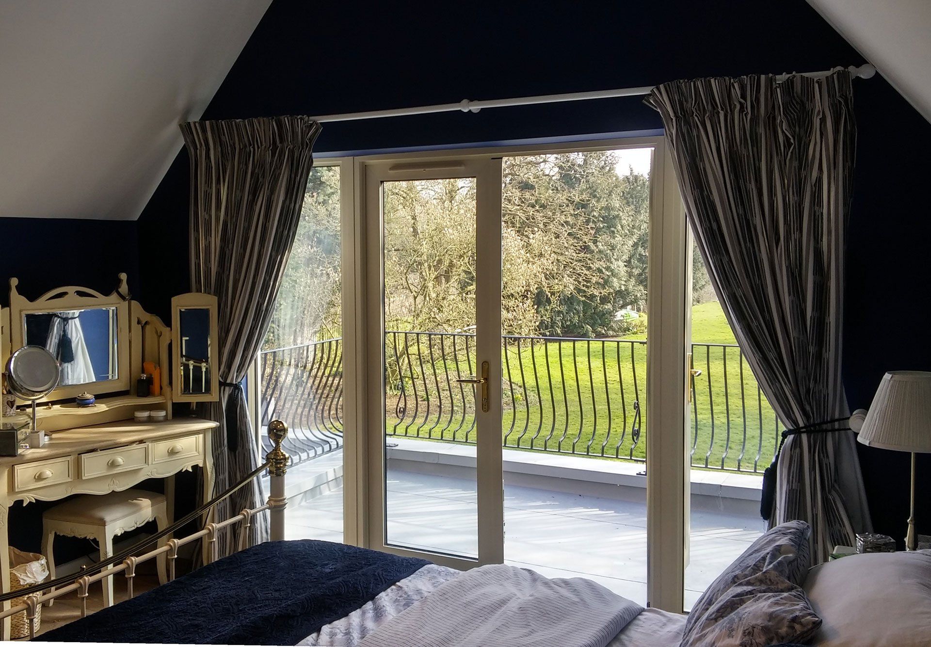 A bedroom with a bed , dresser , mirror and sliding glass doors