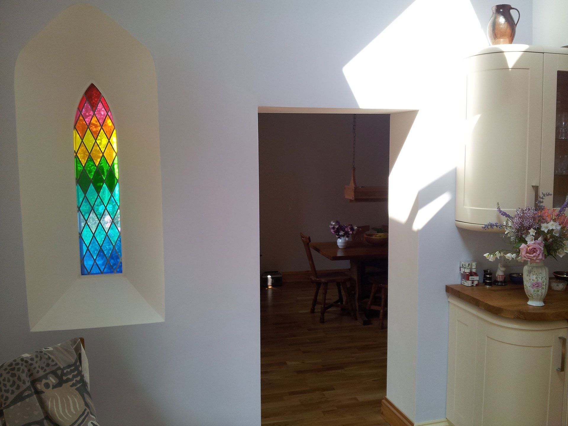 A room with a stained glass window in the corner