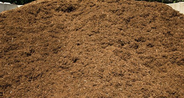 Large brown mound of loose dirt or mulch outdoors