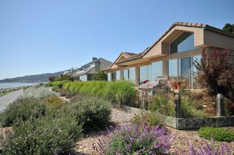 Row of luxury houses near the water with walking path