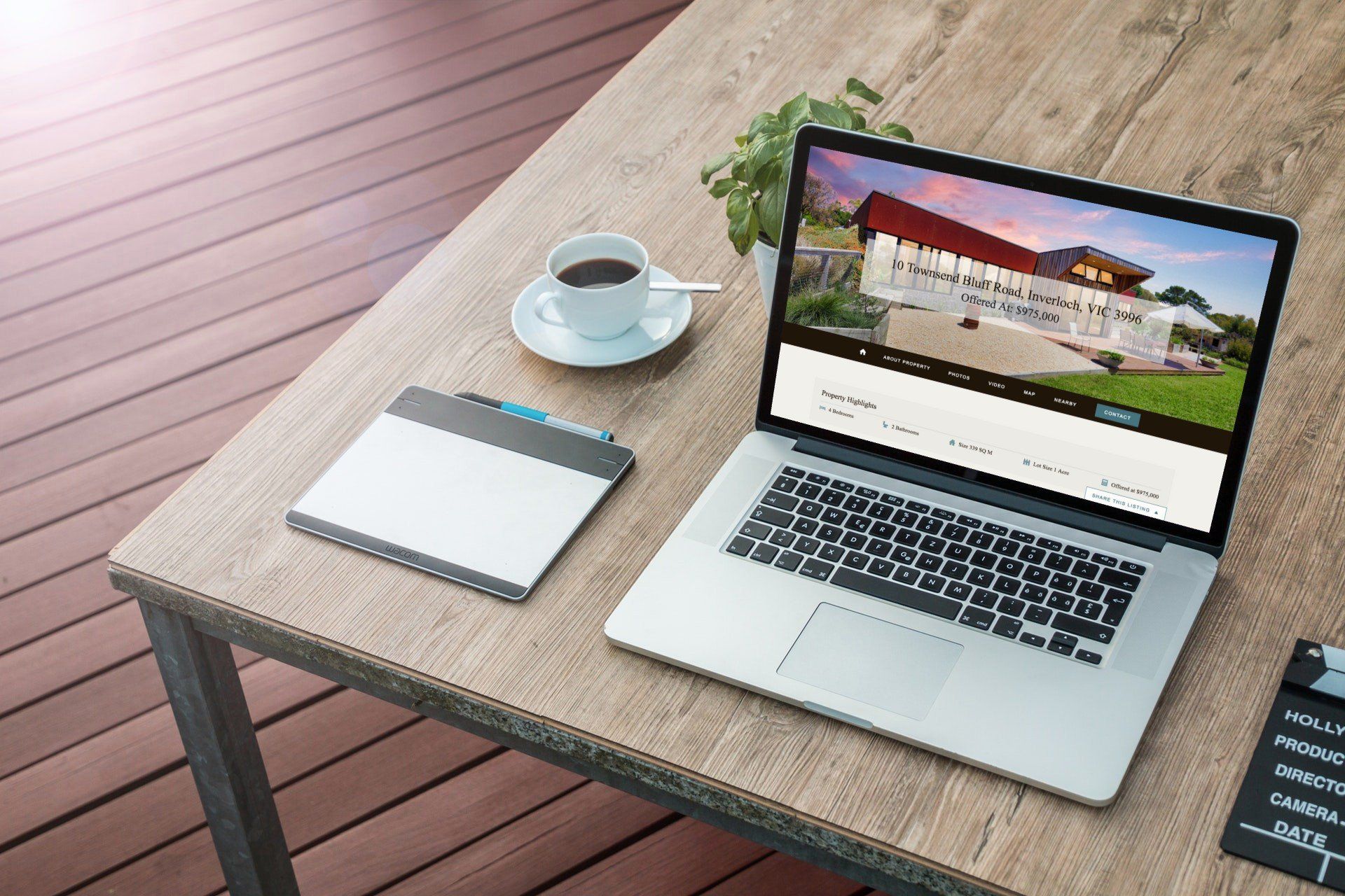 Laptop, notepad, and coffee on a table in a modern outdoor workspace.