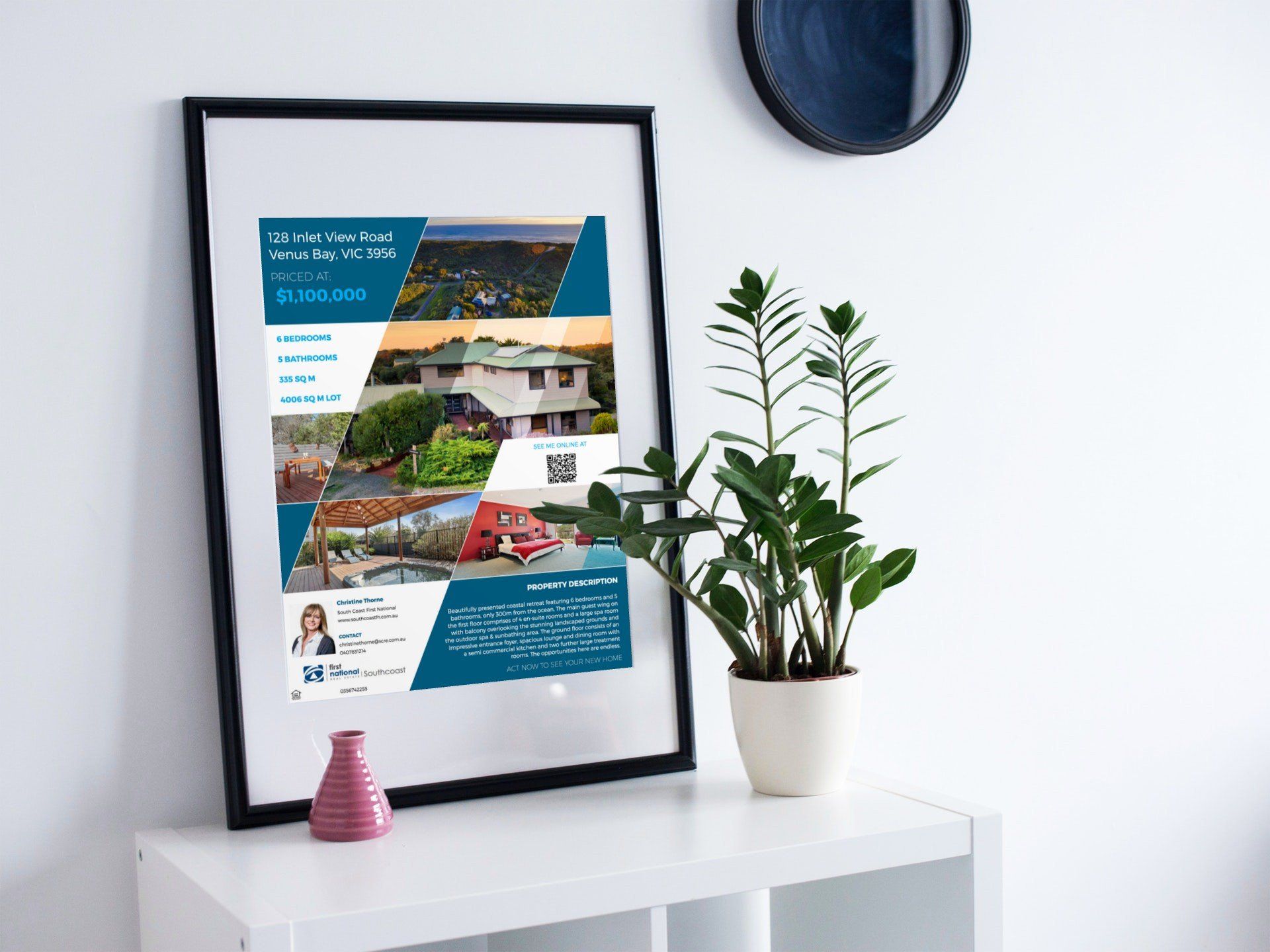 Framed travel poster on a white shelf beside a potted plant and small pink vase