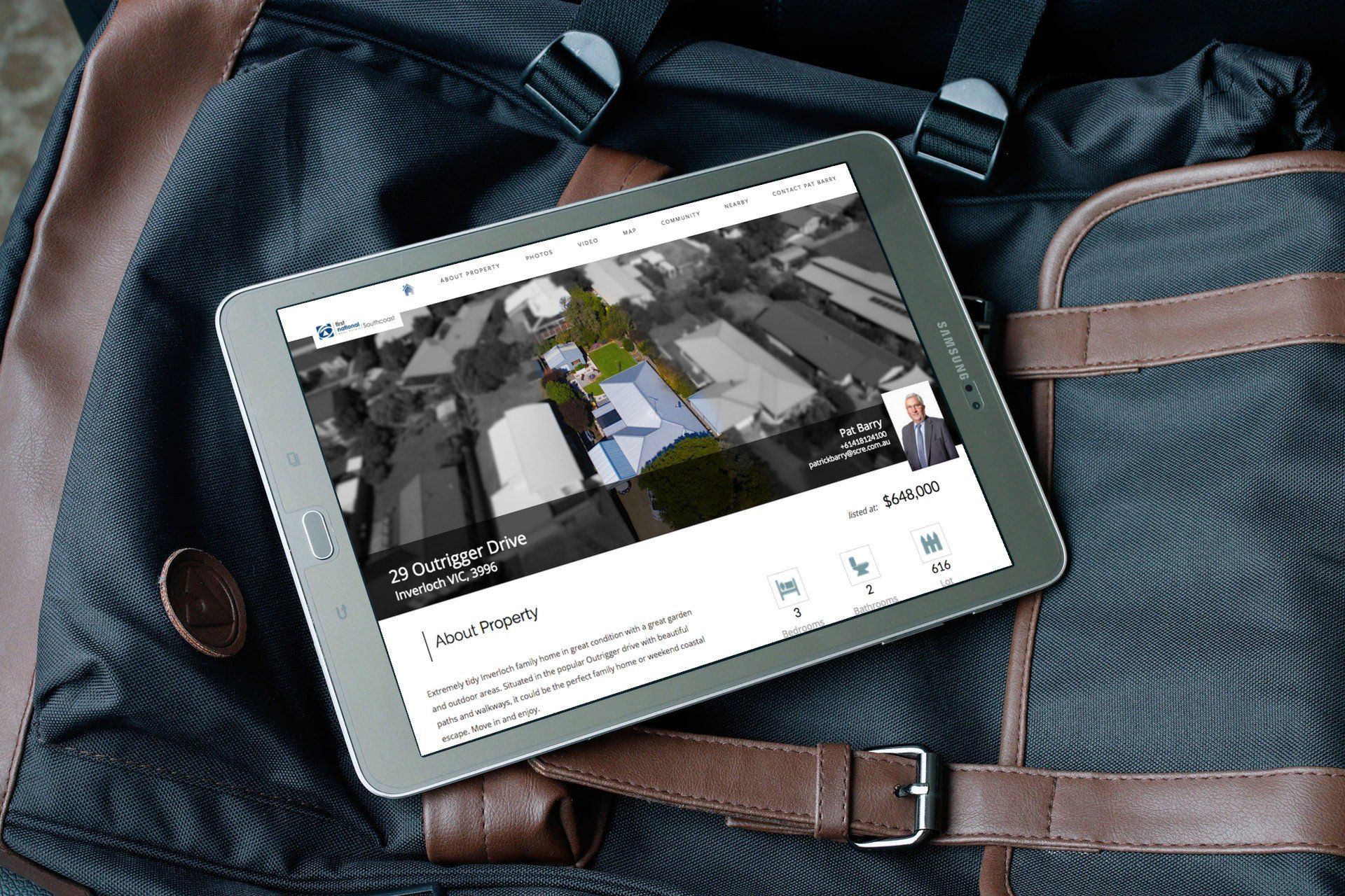Tablet on a blue backpack, displaying a map or city view on its screen.