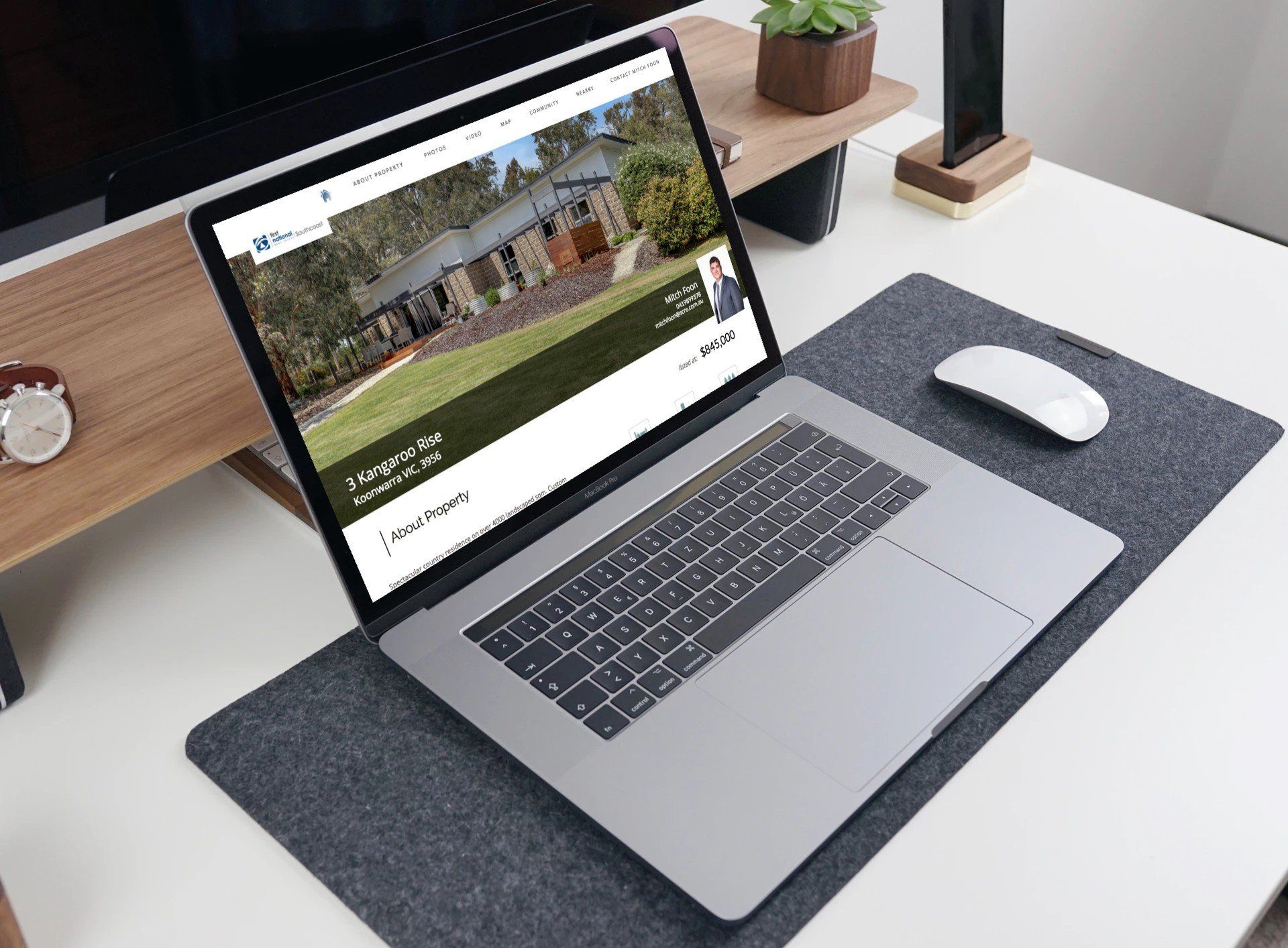 Laptop on a desk with a white mouse, gray mat, and a website open on screen.