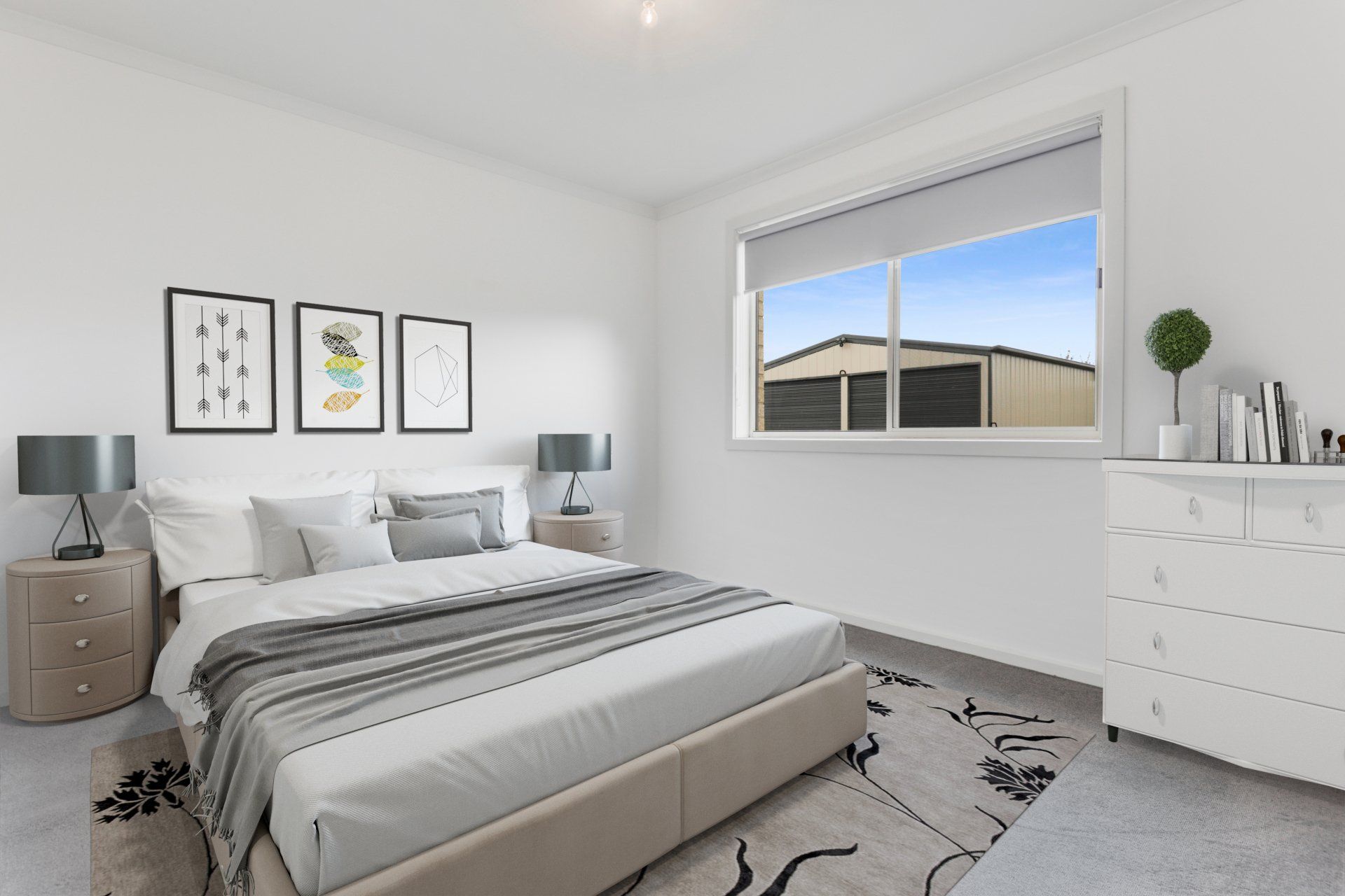 Bright modern bedroom with a gray bed, framed wall art, dresser, and large window showing a neighborhood view