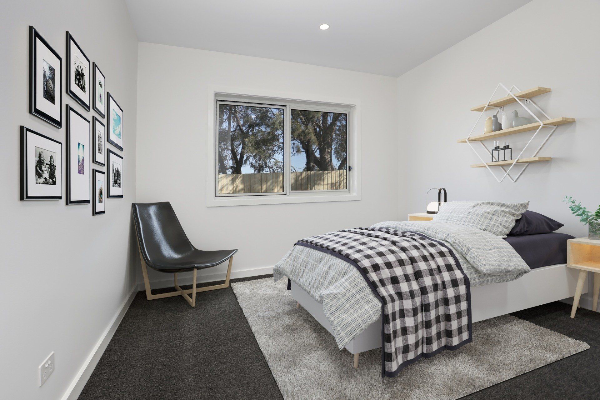 Modern bedroom with gray bedding, black chair, framed wall art, and a window.