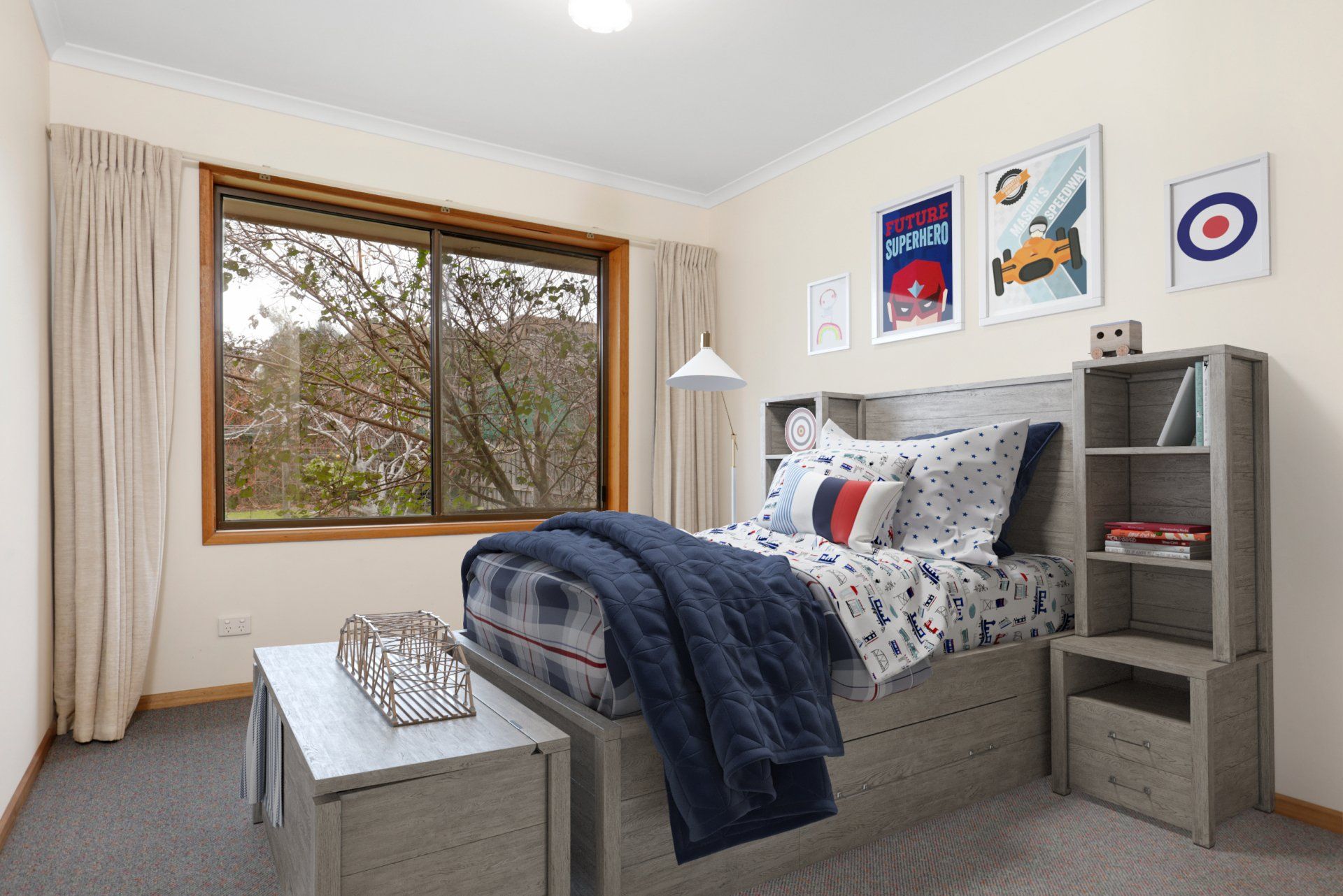Bright bedroom with a bed, navy blanket, window, nightstand, and framed wall art